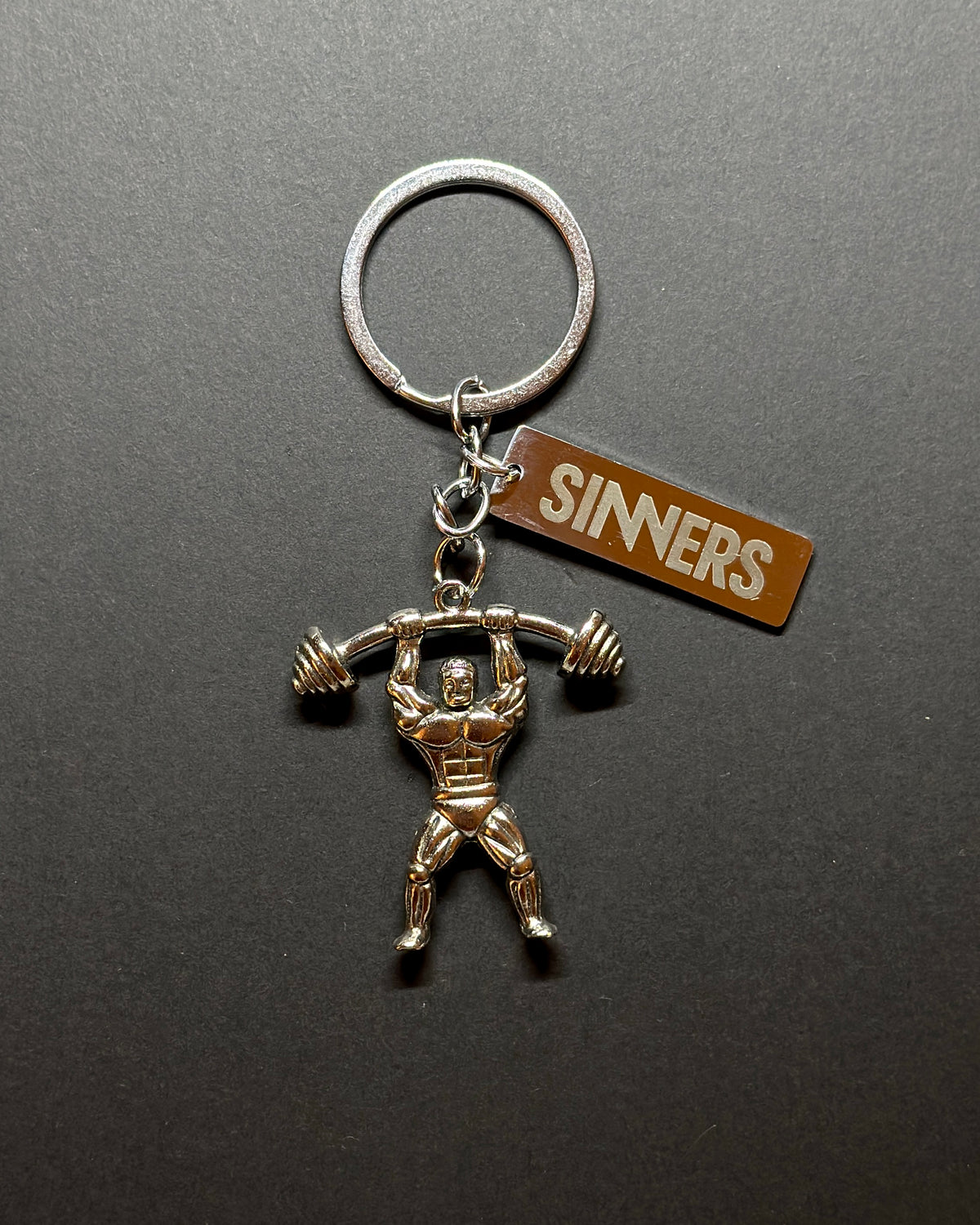 SINNERS kulcstartó – testépítő figura, fém kulcstartó elölnézetben